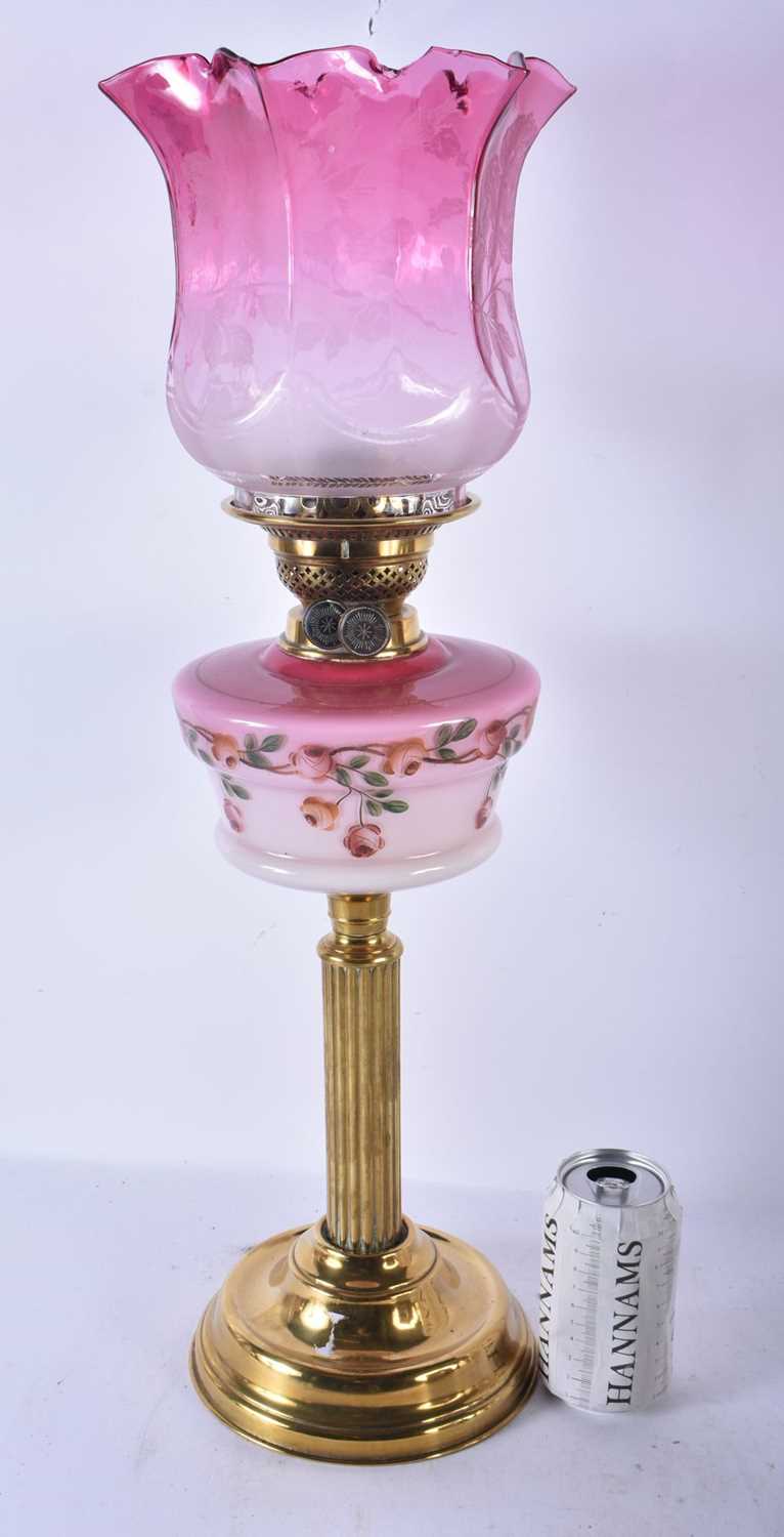 A LARGE ANTIQUE BRASS AND PINK GLASS OIL LAMP. 60 cm high.