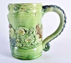 A RARE ANTIQUE GREEN GLAZED WHIELDON TYPE MAJOLICA MUG decorated in relief with figures. 14 cm x
