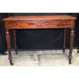 A 19th Century two drawer writing table with castors fitted to tapering legs 76 x 106 x 54.5 cm.