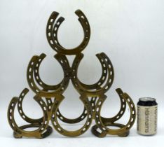 A brass horse shoe wine rack 40 x 42 cm.