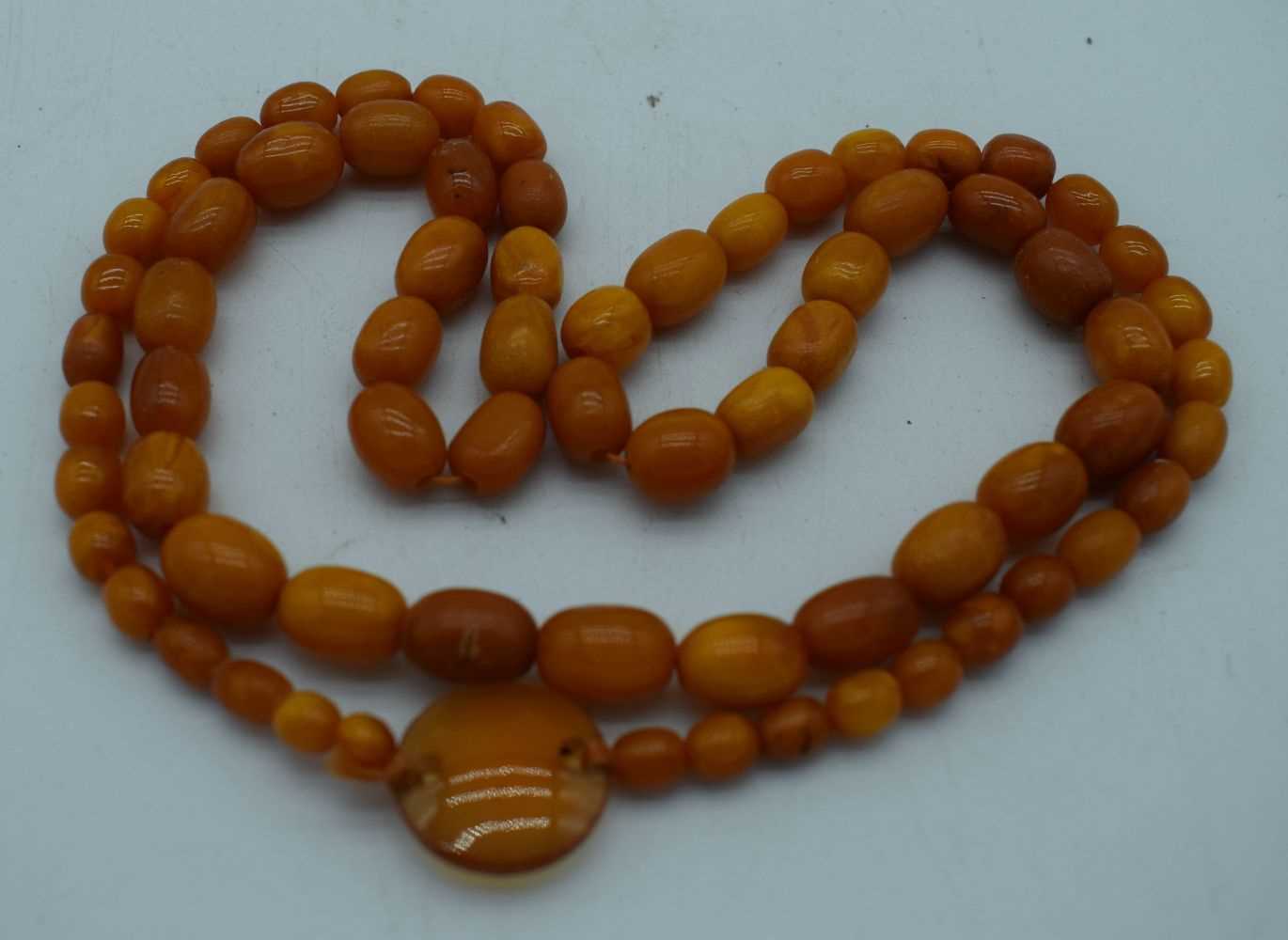 AN AMBER AND AGATE NECKLACE. 41 grams. 82 cm long. Largest amber bead 1.75 cm x 0.75 cm.