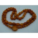 AN AMBER AND AGATE NECKLACE. 41 grams. 82 cm long. Largest amber bead 1.75 cm x 0.75 cm.