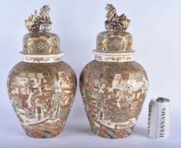 A LARGE PAIR OF LATE 19TH CENTURY JAPANESE MEIJI PERIOD SATSUMA VASES AND COVERS painted with