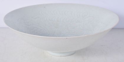 A Chinese porcelain Celadon glazed bowl decorated to the interior with figures and symbols in relief