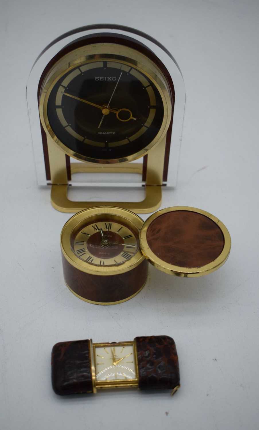 A TRAVELLING MOVADO LEATHER CASED WATCH together with two clocks. Largest 15cm x 10cm. (3)