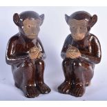 A PAIR OF 19TH CENTURY CHINESE PAINTED POTTERY MONKEYS possibly incense or joss stick holders. 17 cm