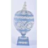 A LOVELY WEDGWOOD BLUE JASPER WARE VASE AND COVER formed with a putti finial, upon a body