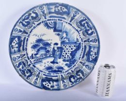 AN EARLY DELFT TIN GLAZED POTTERY PLATE painted with a figure within a landscape. 32 cm diameter.