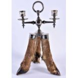 A RARE VICTORIAN TAXIDERMY ROWLAND WARD CANDLESTICK formed with three deer hooves. 32 cm x 16 cm.