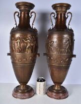 A pair of large Grecian bronze Urns set on a marble base decorated in relief with figures and