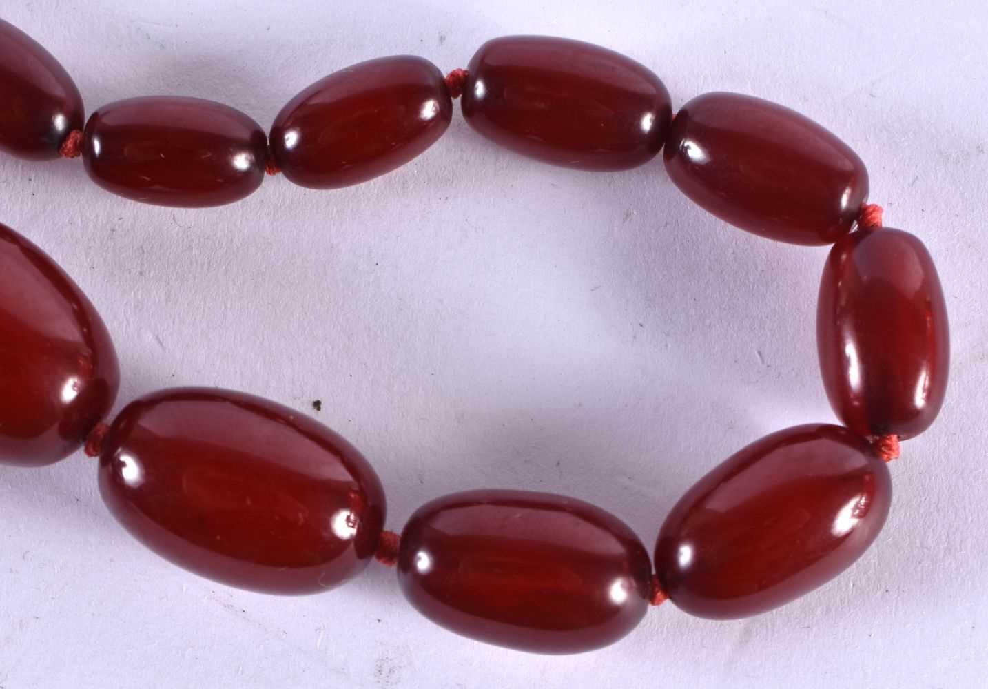 A Graduated Cherry Amber Bead Necklace. 78cm long, largest bead 23mm, smallest bead 7mm, total - Bild 3 aus 8