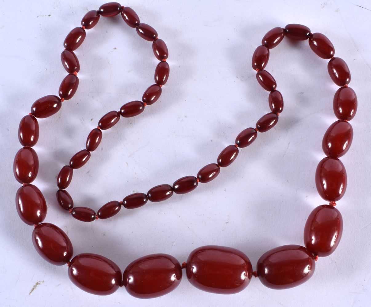 A Graduated Cherry Amber Bead Necklace. 78cm long, largest bead 23mm, smallest bead 7mm, total
