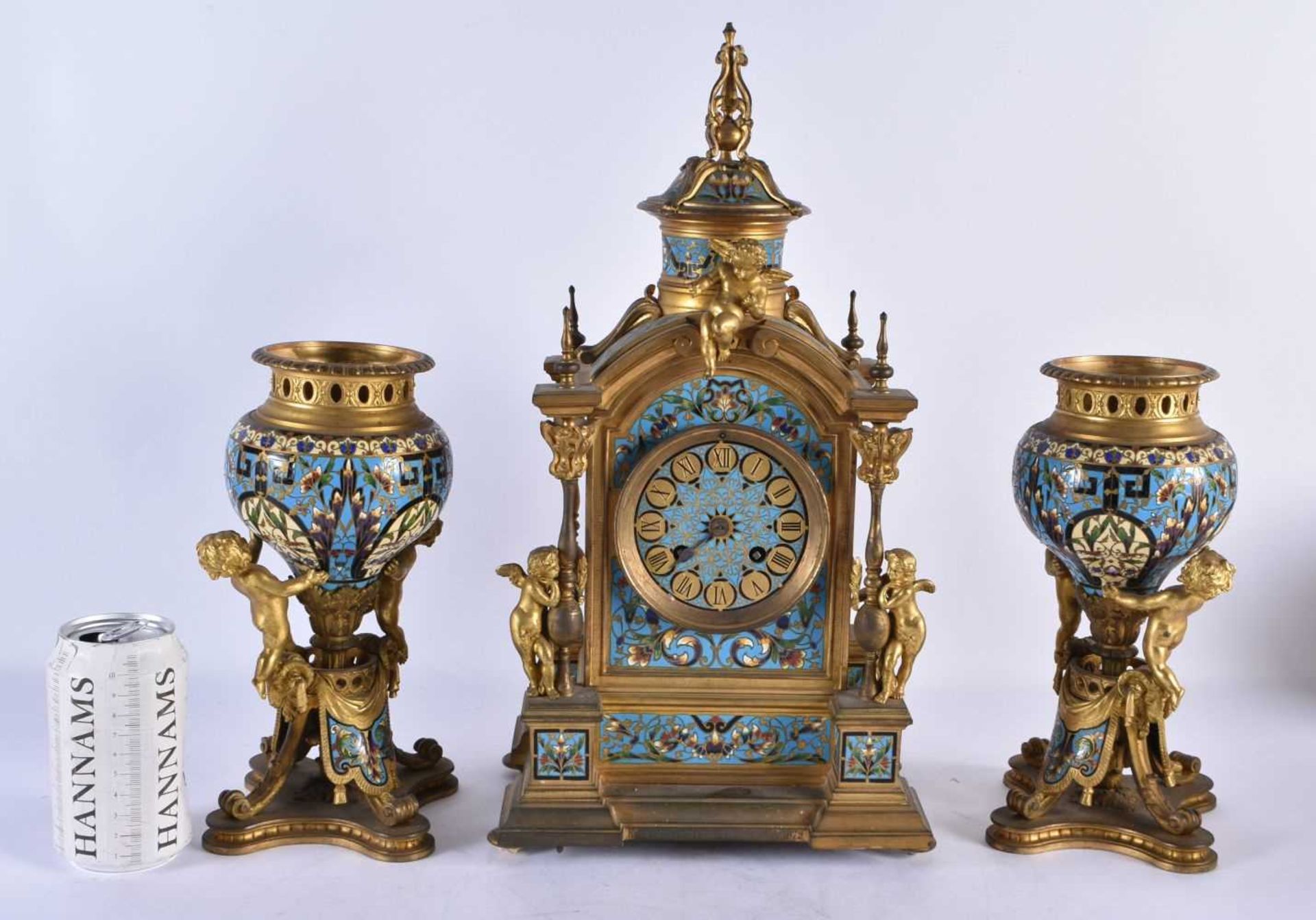 A FINE 19TH CENTURY FRENCH ORMOLU AND CHAMPLEVE ENAMEL CLOCK GARNITURE formed with putti amongst