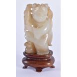 A 19TH CENTURY CHINESE CARVED JADE FIGURE OF A YOUNG CHILD Qing, modelled holding foliage. 7.5 cm