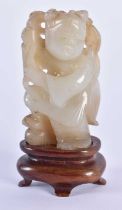 A 19TH CENTURY CHINESE CARVED JADE FIGURE OF A YOUNG CHILD Qing, modelled holding foliage. 7.5 cm