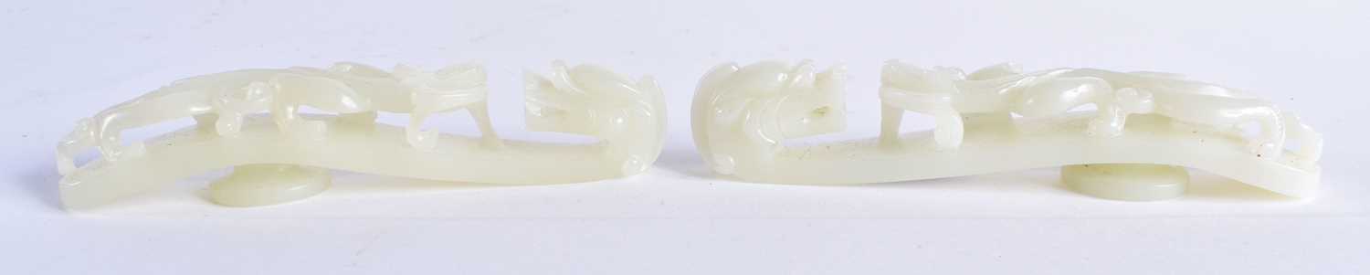A FINE PAIR OF CHINESE QING DYNASTY CARVED GREENISH WHITE JADE BELT HOOKS Qing, formed as stylised
