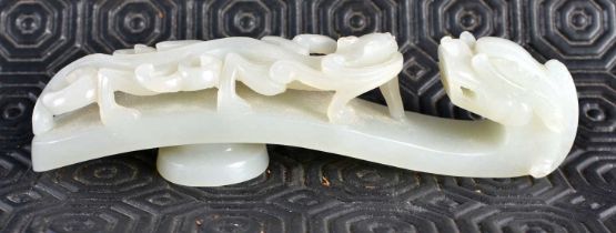 A FINE 17TH/18TH CENTURY CHINESE CARVED GREENISH WHITE JADE BELT HOOK Yongzheng, formed as a