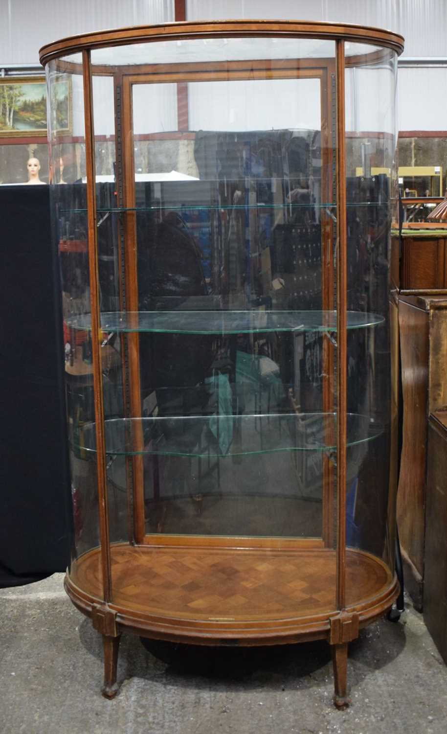 A large mahogany Edwardian bow fronted glass display cabinet with glass shelves and a wooden