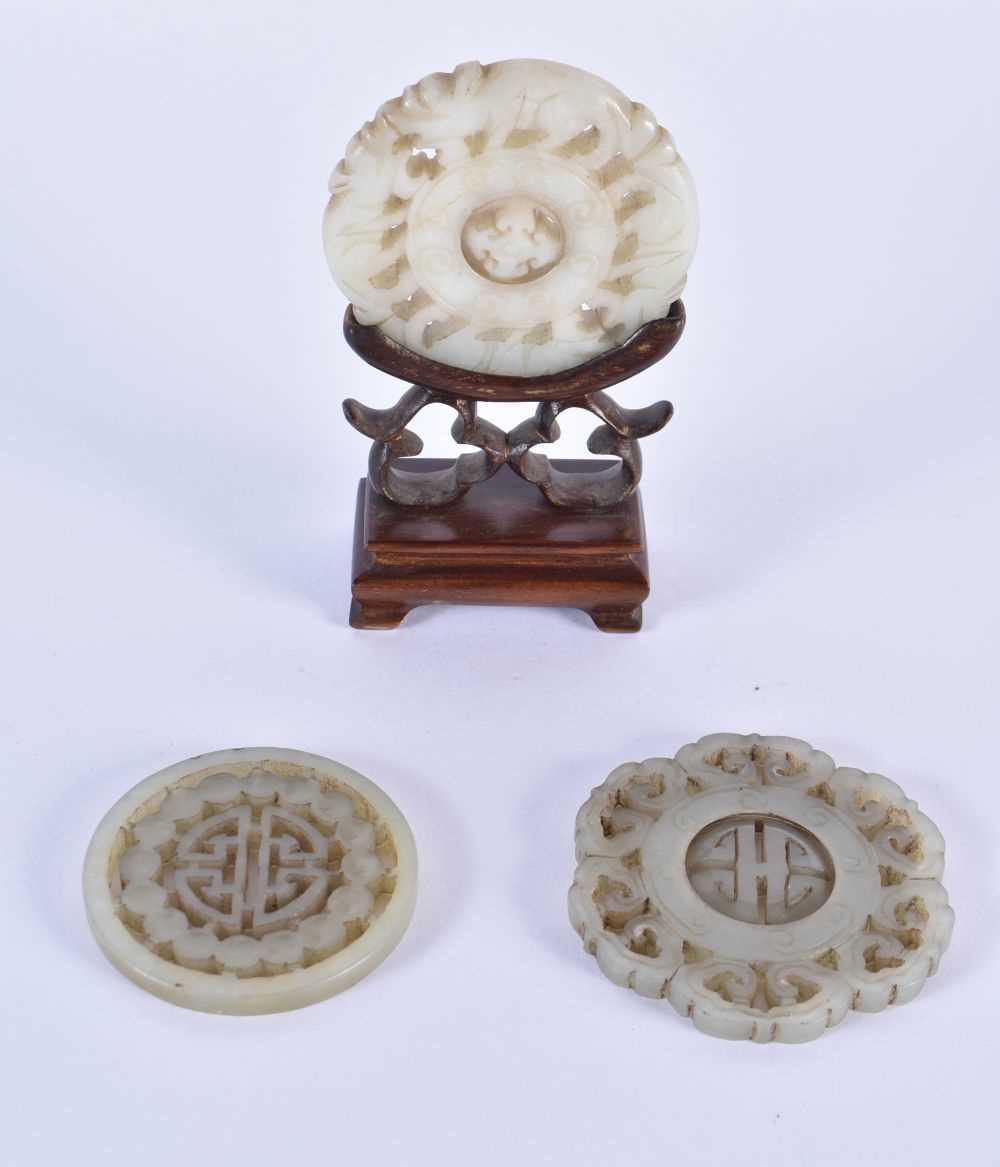 THREE 19TH CENTURY CHINESE CARVED JADE ROUNDELS Qing, in various designs and sizes. Largest 6.25
