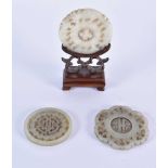 THREE 19TH CENTURY CHINESE CARVED JADE ROUNDELS Qing, in various designs and sizes. Largest 6.25