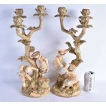 A RARE PAIR OF ROYAL WORCESTER HADLEYS BLUSH IVORY FIGURAL CANDLESTICKS modelled as children upon
