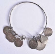 A Victorian Bracelet with 8 coins (charms). 6.4cm internal diameter, weight 19g.