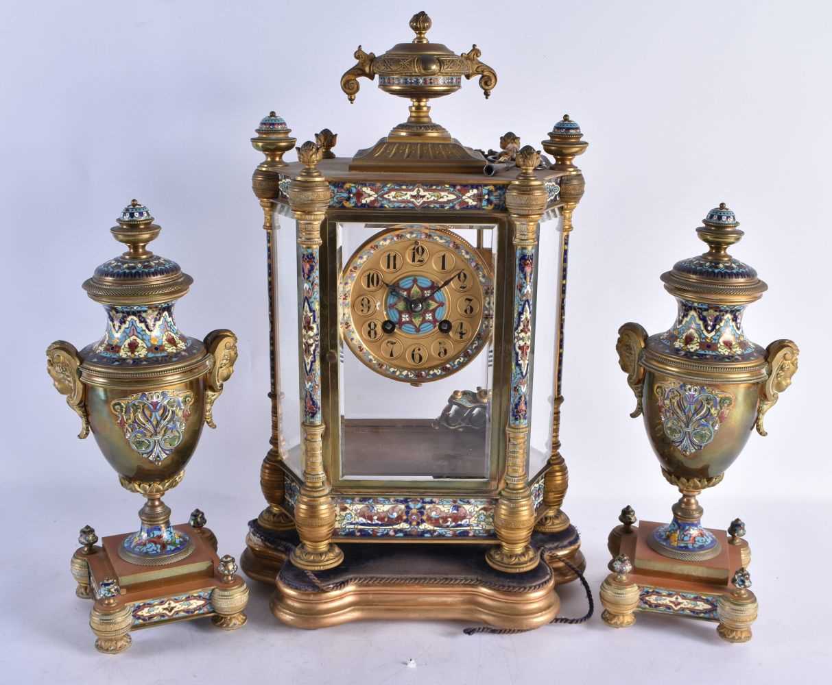 A LARGE LATE 19TH CENTURY FRENCH BRONZE AND CHAMPLEVE ENAMEL CLOCK GARNITURE decorated with foliage.