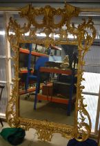 A VERY LARGE LATE 19TH/20TH CENTURY CARVED COUNTRY HOUSE GILTWOOD MIRROR of scrolling form. 158 cm x