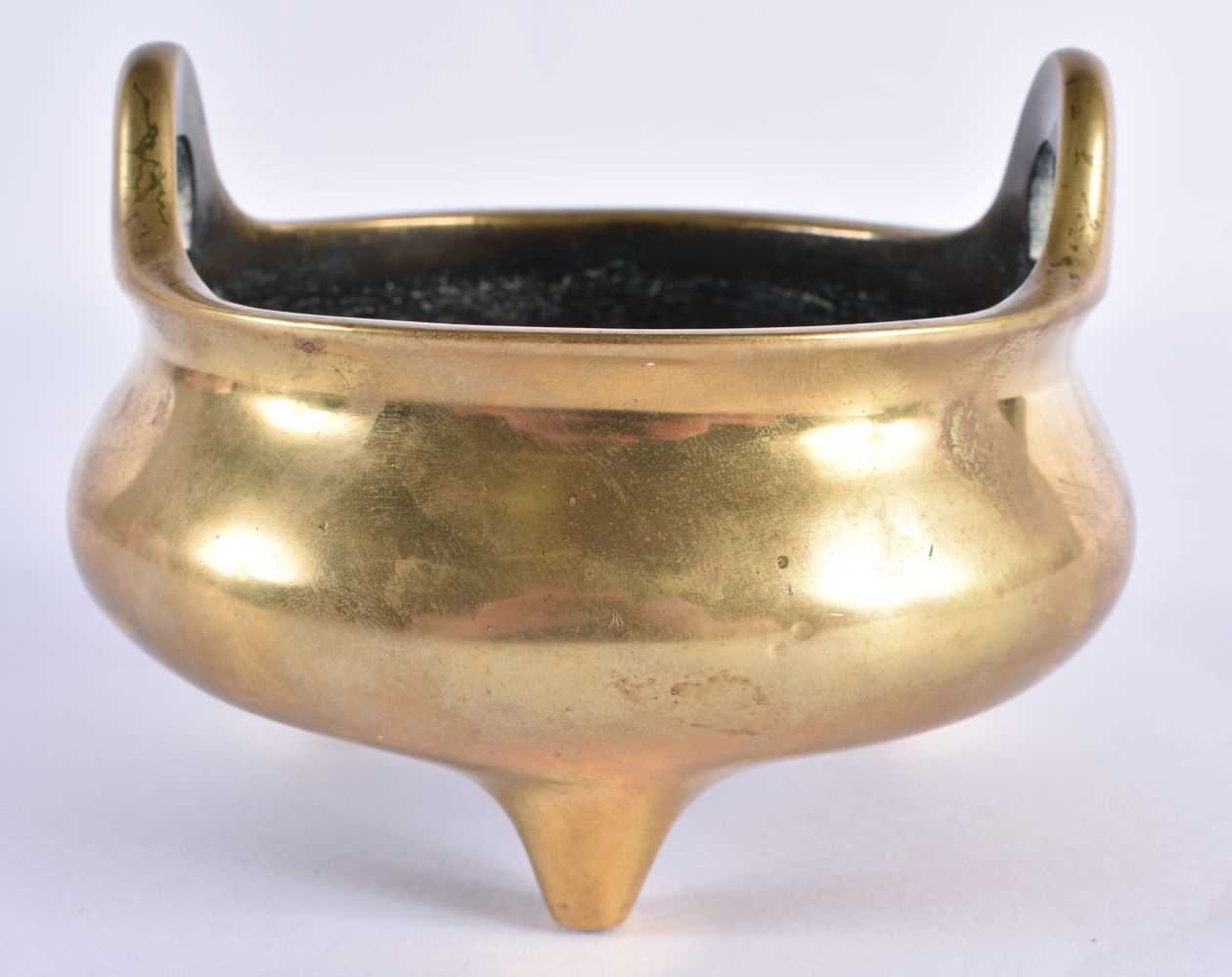 AN 18TH CENTURY CHINESE TWIN HANDLED BRONZE CENSER with high loop handles, bearing Xuande marks to