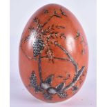 AN EARLY 20TH CENTURY CONTINENTAL CORAL GROUND PORCELAIN EGG painted with black floral sprays and