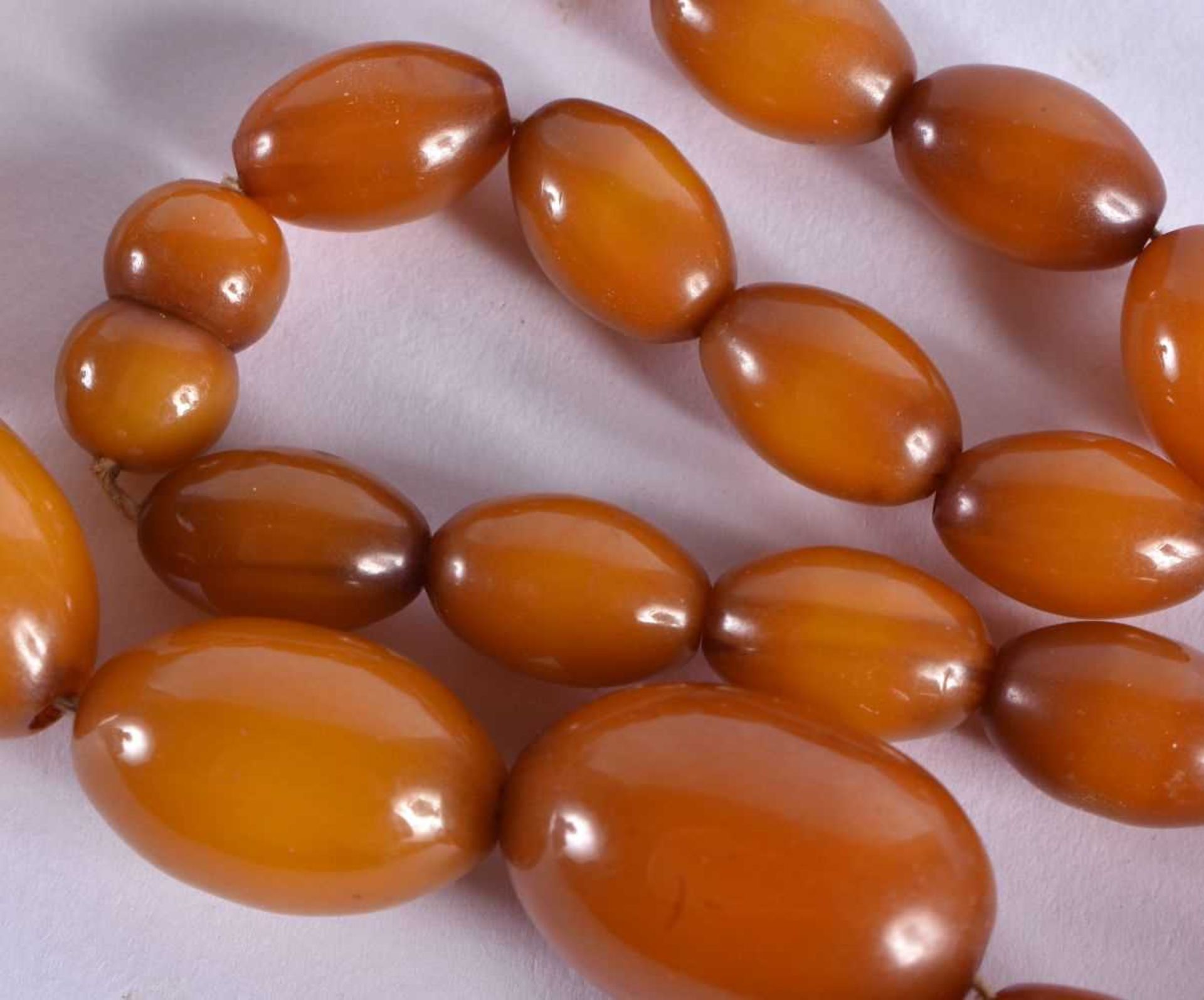 AN EARLY 20TH CENTURY CARVED BUTTERSCOTCH AMBER NECKLACE. 39 grams. 50 cm long, largest bead 2.75 cm - Image 4 of 4