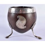 A GEORGE III WHITE METAL MOUNTED COCONUT CUP formed with a scrolling cartouche, upon splayed legs.