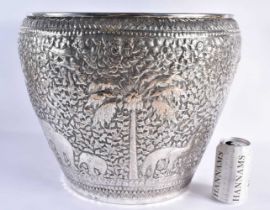 A VERY LARGE LATE 19TH CENTURY INDIAN WHITE METAL JARDINIERE decorative with animals and palm trees,