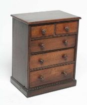 A MAHOGANY MINIATURE CHEST, early/mid 19th century, of two short over three long drawers with turned