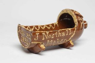 A DOCUMENTARY SLIPWARE CRADLE, 1829, with finial to the hood and applied with S scrolls and