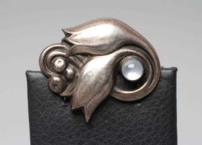 A GEORG JENSEN BROOCH cast as two stylised buds and centred by a circular polished moonstone,