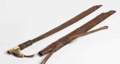 A DAYAK HEAD-HUNTER'S SWORD, the 21" blade shaped and decorated at the tip, carved bone handle,