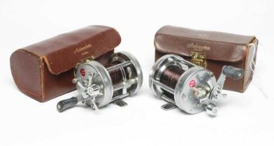 TWO ABU AMBASSADEUR 6500C FISHING REELS, both bright metal and in leather cases (Est. plus 24%