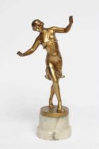 AN ART DECO GILDED SPELTER DANCING FIGURE cast as a scantily draped young lady, her arms