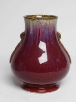 A CHINESE SANG DE BOEUF GLAZED VASE of baluster form with two fixed ring and tassel 'handles',