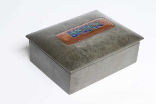 A TUDRIC PEWTER BRIDGE CARD BOX of plain oblong form, the slightly domed cover centred by a copper