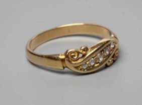 A LATE VICTORIAN DIAMOND RING, the five rose cut stones in a crossover setting with carved scroll