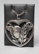 A GEORG JENSEN SILVER HEART SHAPED PENDANT designed by Arno Malinowski with a dove and olive branch,