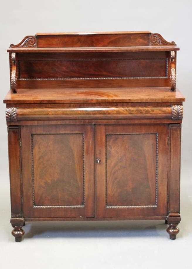 A VICTORIAN MAHOGANY CHIFFONIER, the panelled back with scroll carved surmount and shelf on scroll