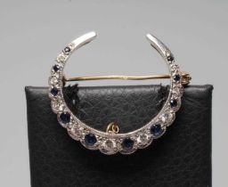 A SAPPHIRE AND DIAMOND CRESCENT BROOCH, the ten graduated small sapphires and nine brilliant cut