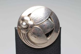 A GEORG JENSEN SILVER BROOCH of circular domed form cast and pierced with a stylised flowerhead with