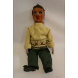 A vintage ventriloquist dummy, with papier mache head, painted wood eyes with sideways glancing pull