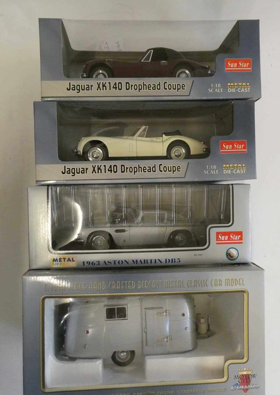 Three Sunstar 1/18th scale cars comprising Jaguar XK 140, Aston Martin DB5 and Motor City Classics