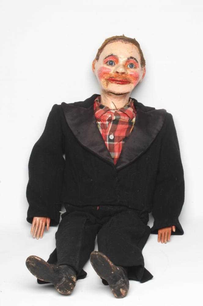 A ventriloquist dummy, circa 1930s, the papier mache head with blue glass eyes with sideways