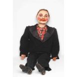 A ventriloquist dummy, circa 1930s, the papier mache head with blue glass eyes with sideways